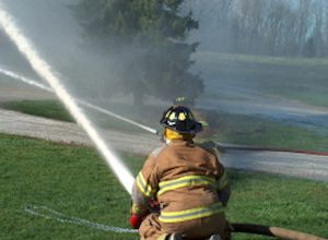 Fireman putting out blaze with a hose